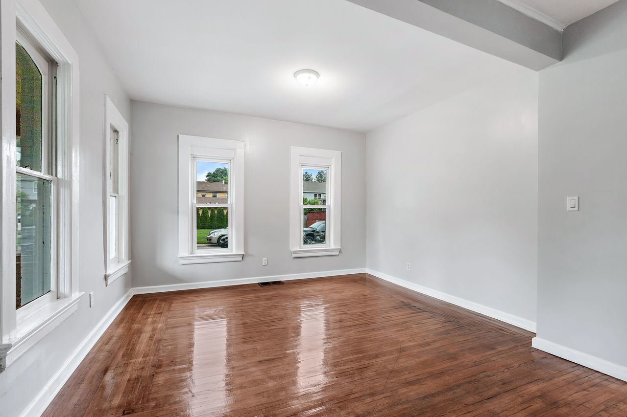 319 Wabash Street Elgin, IL 60123 - Photo 3 of 18 an empty room with wooden floor and windows