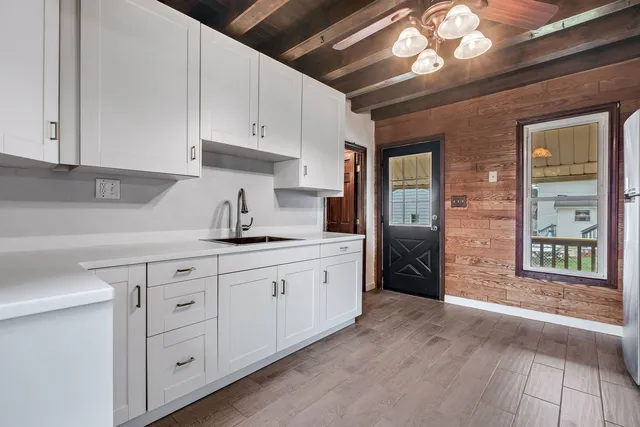 a kitchen with granite countertop white cabinets and stainless steel appliances