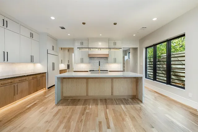 a large kitchen with kitchen island a sink stainless steel appliances and cabinets