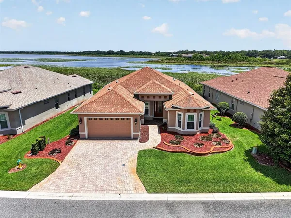 an aerial view of a house with swimming pool and a yard