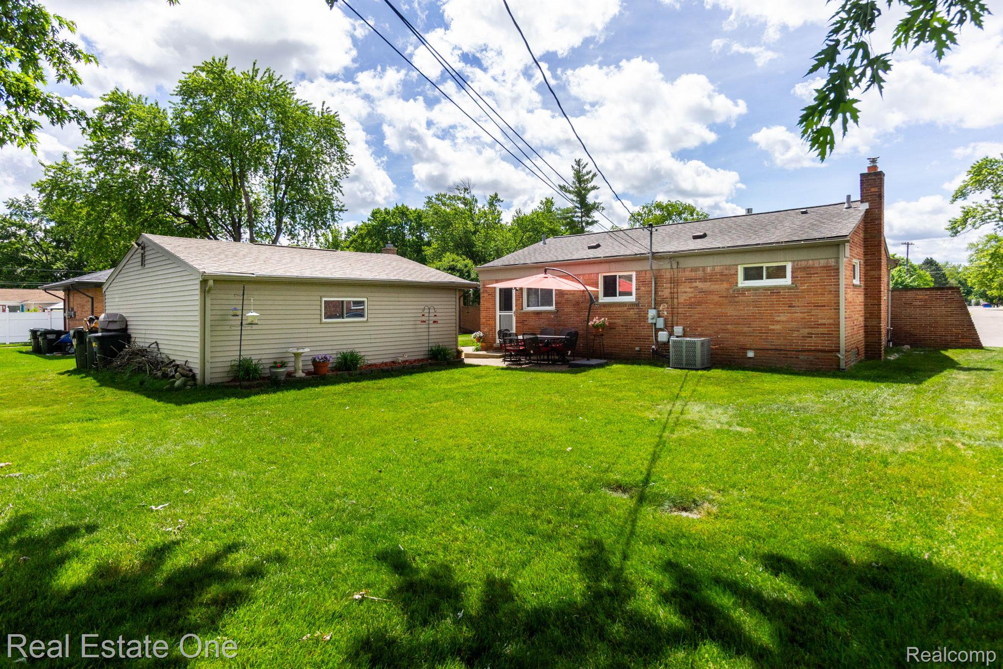 220 Winry Drive Rochester, MI 48307 - Photo 28 of 35 Expansive green lawn with a detached auxiliary building and a brick exterior dwelling