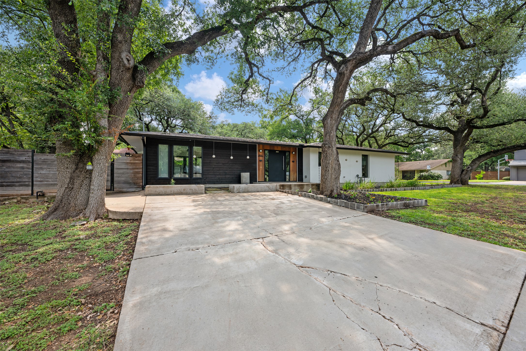 8900 Point W Drive Austin, TX 78759 - Photo 3 of 40 Mature trees shade this modern facade, offering exceptional curb appeal and a serene welcome.