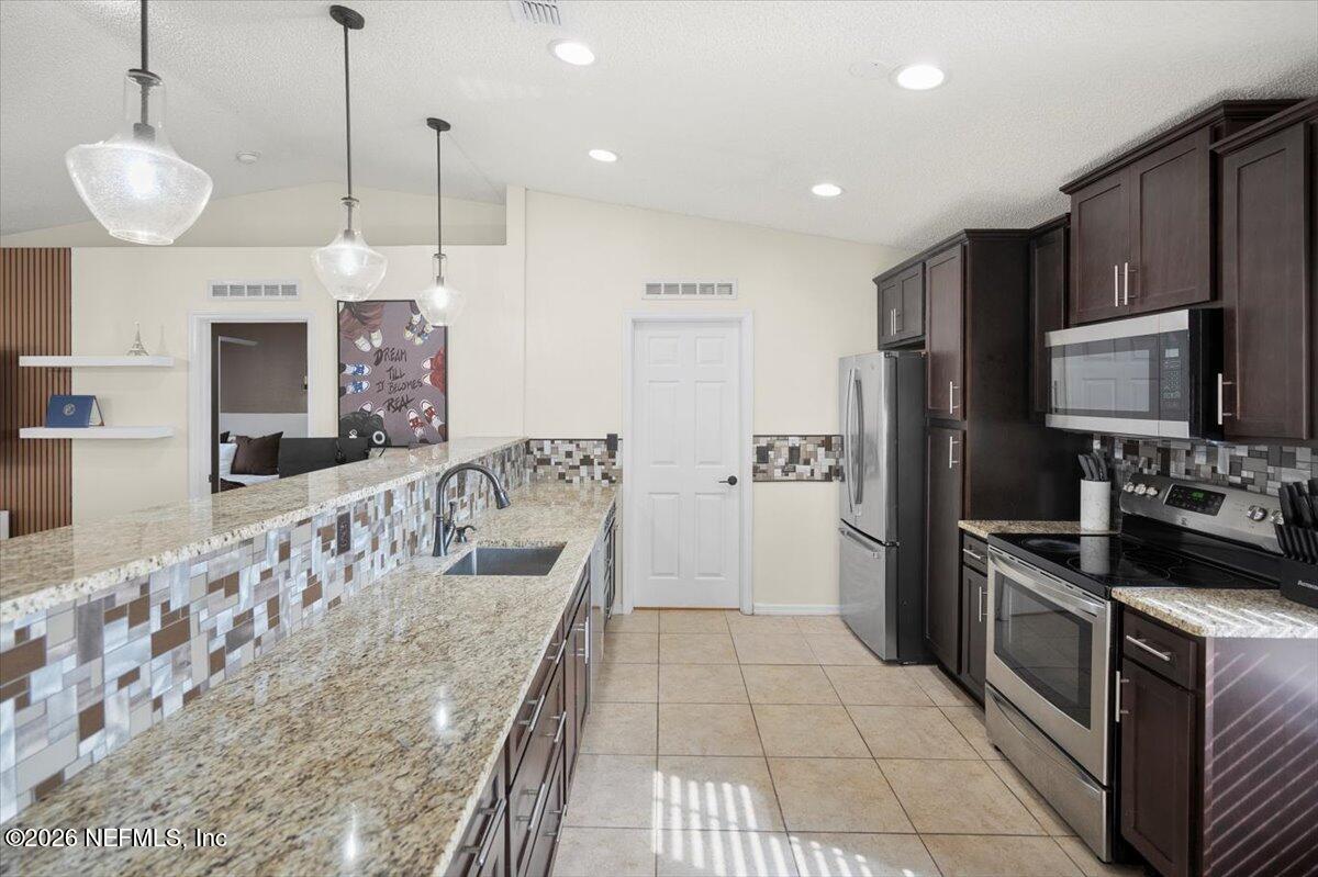10310 Woodley Point Road Jacksonville, FL 32218 - Photo 6 of 30 a kitchen with stainless steel appliances granite countertop a sink a stove and a refrigerator