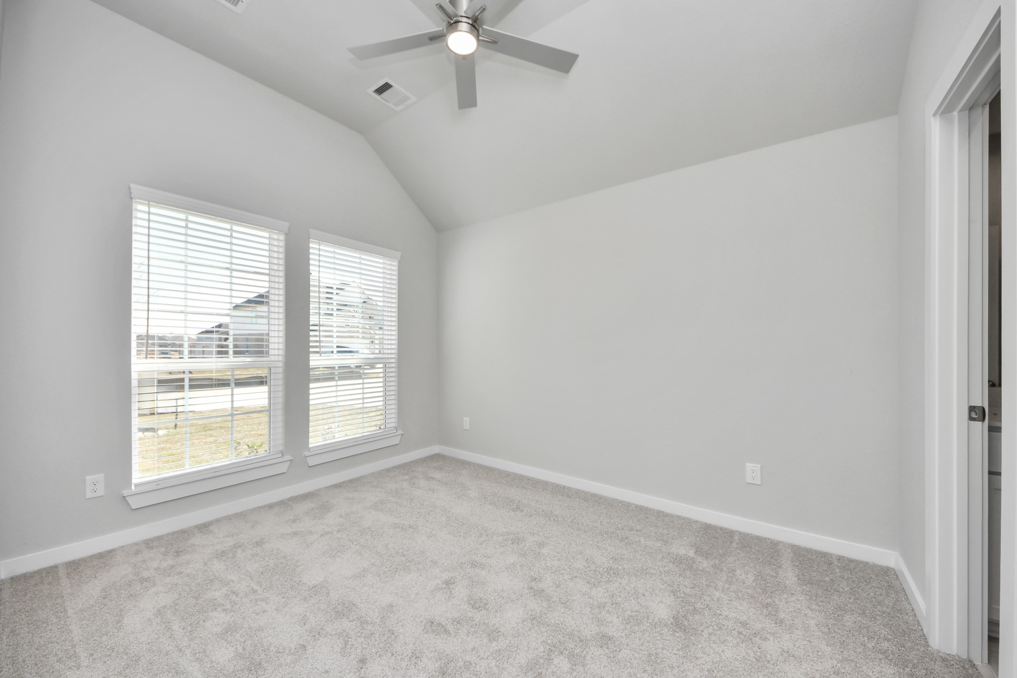 311 Ice Shr Trail Dayton, TX 77535 - Photo 4 of 35 Secondary bedroom features plush carpeting, large windows that let in plenty of natural light, bright paint, and spacious closets. Sample photo of completed home with similar floor plan. Actual colors and selections may vary.