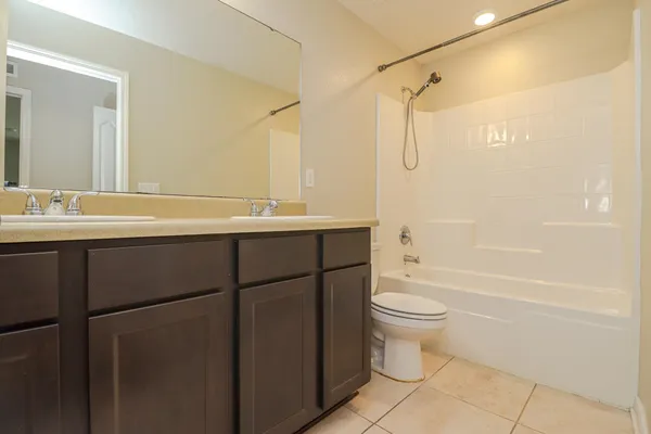 a bathroom with a granite countertop sink mirror and a toilet