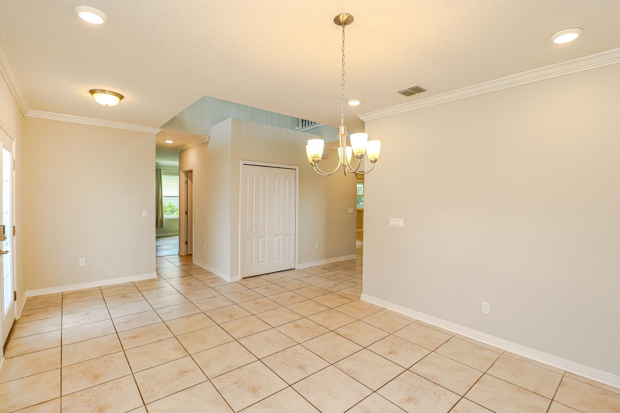 554 Tumbled Stone Way St. Augustine, FL 32086 - Photo 4 of 44 a view of a hallway with chandelier