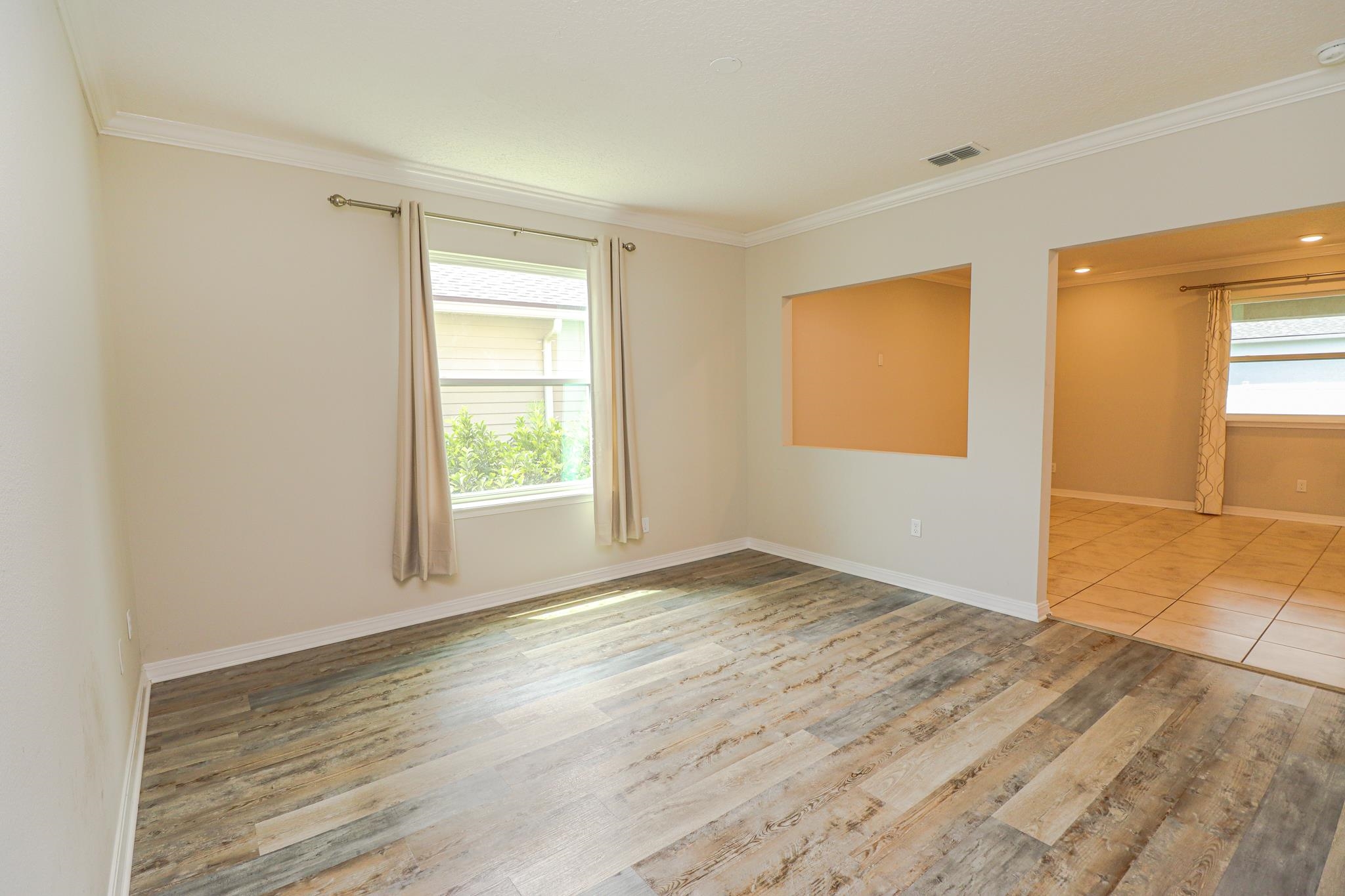 554 Tumbled Stone Way St. Augustine, FL 32086 - Photo 6 of 44 a view of an empty room with wooden floor and a window