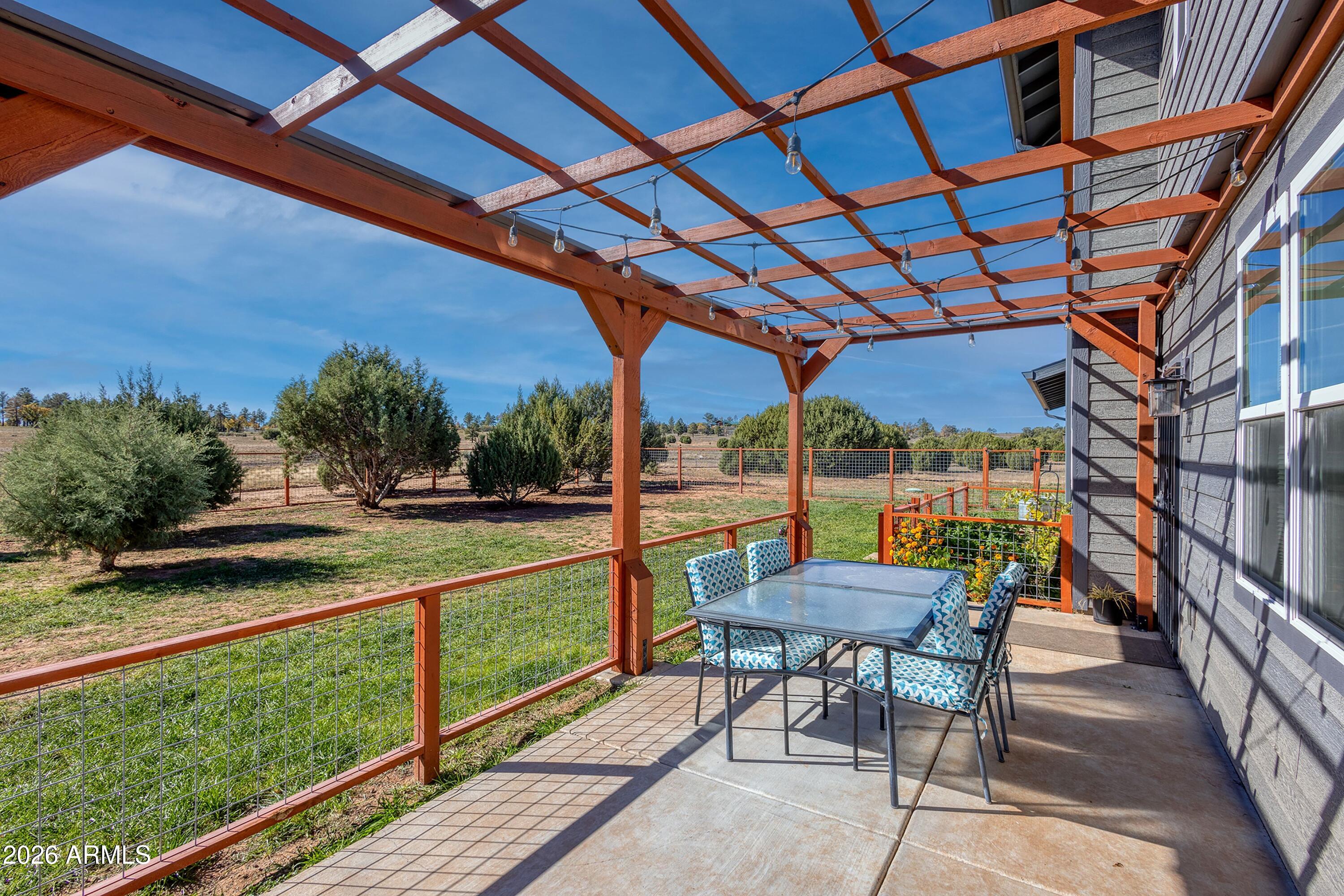 1898 Rocky Lane Show Low, AZ 85901 - Photo 7 of 59 a view of a patio with a table and chairs under an umbrella with a small yard