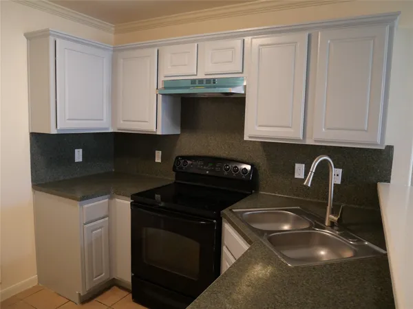 a kitchen with granite countertop white cabinets and black appliances