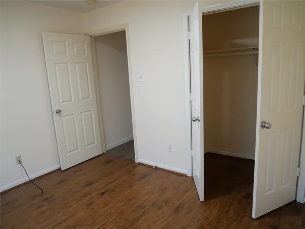 an empty room with wooden floor and closet