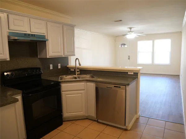 a kitchen with kitchen island granite countertop a sink cabinets and stainless steel appliances