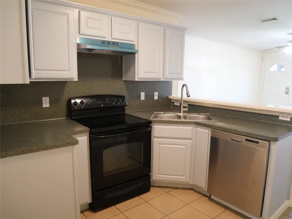 a kitchen with granite countertop white cabinets and white appliances