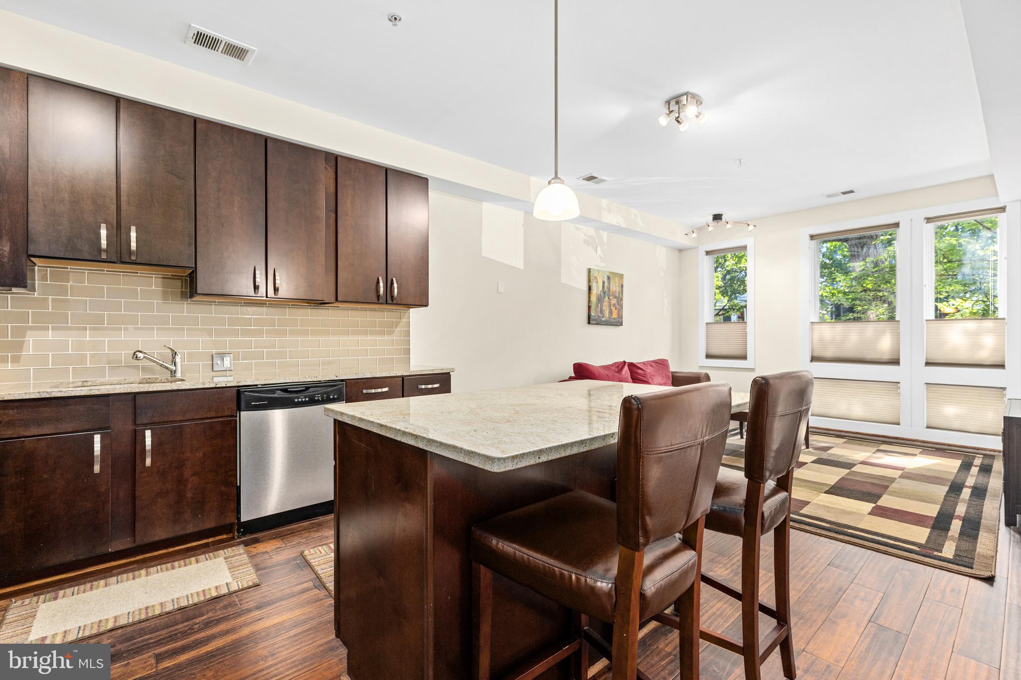 245 15th Street Southeast, Unit 105 Washington, DC 20003 - Photo 2 of 29 a kitchen with stainless steel appliances granite countertop wooden floors and wooden cabinets