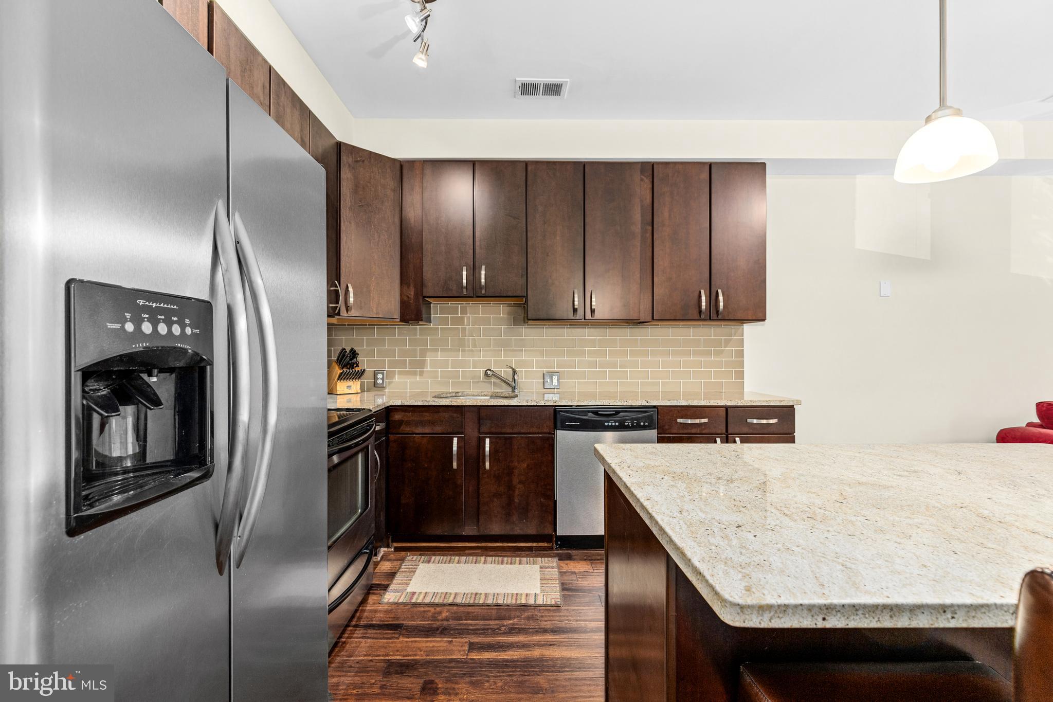 245 15th Street Southeast, Unit 105 Washington, DC 20003 - Photo 3 of 29 a kitchen with stainless steel appliances granite countertop a sink a stove and refrigerator