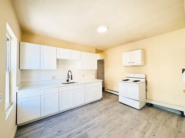 a kitchen with a sink cabinets stainless steel appliances and a window