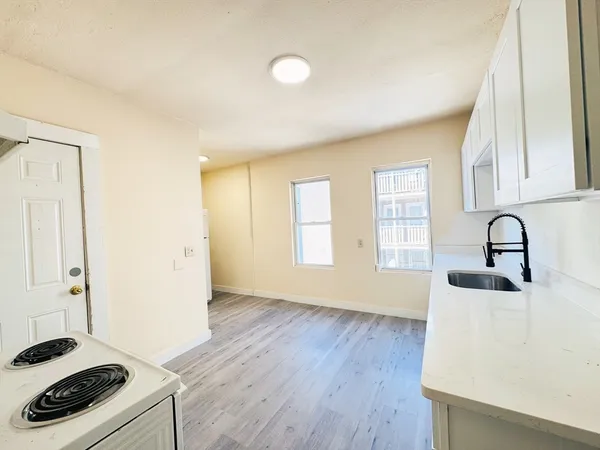 a kitchen with granite countertop a stove and a sink