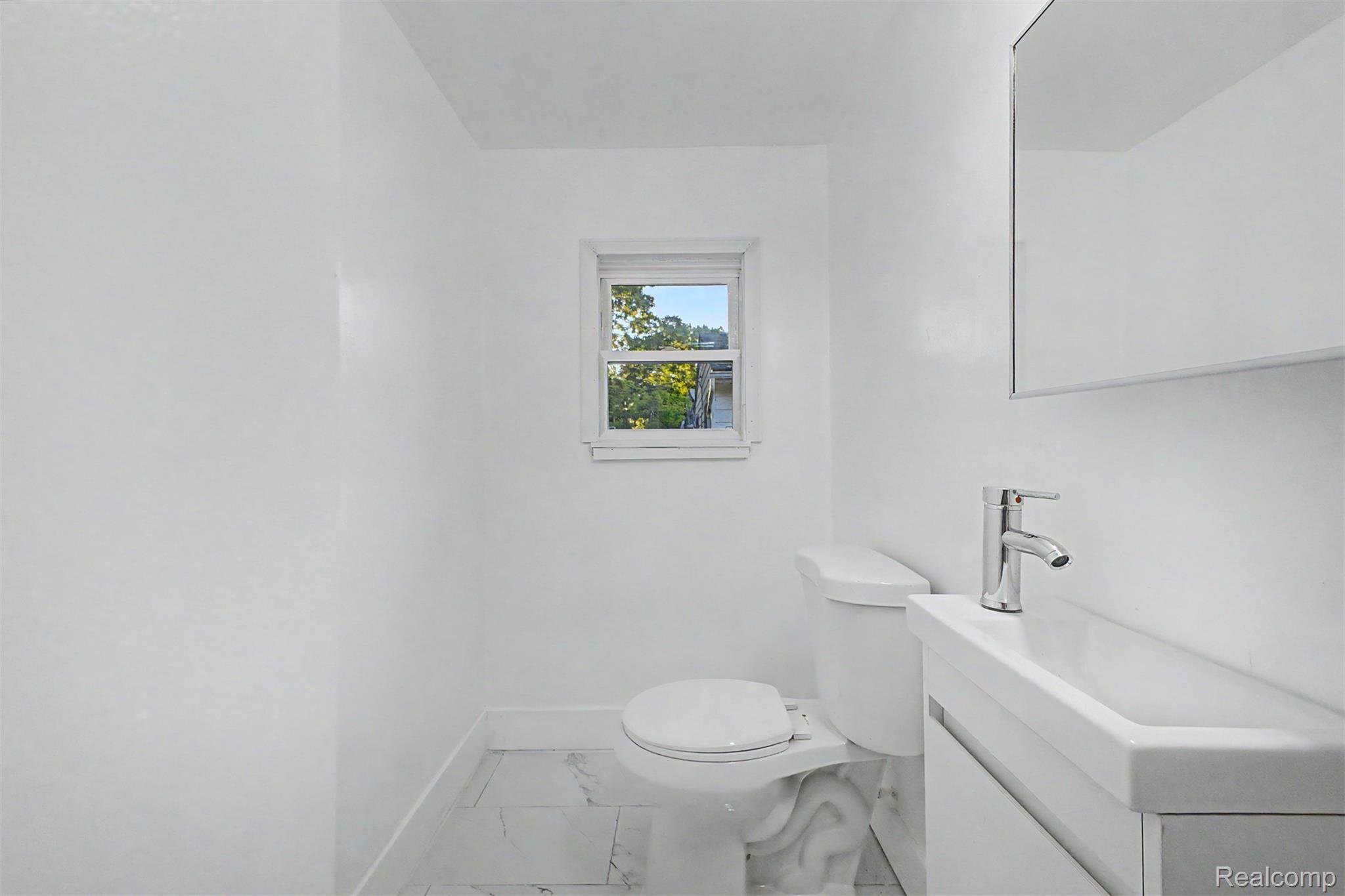 26718 Penn Street Inkster, MI 48141 - Photo 18 of 27 Bathroom featuring a white floating vanity with an integrated sink, polished chrome faucet, and a wall-mounted medicine cabinet