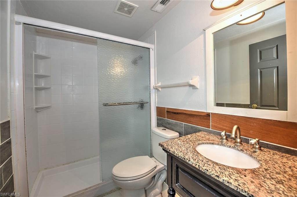 19066 Flamingo Road Fort Myers, FL 33967 - Photo 17 of 29 a bathroom with a granite countertop sink toilet and shower