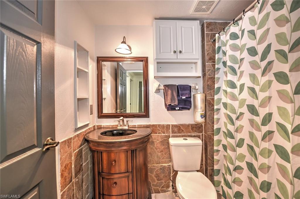 19066 Flamingo Road Fort Myers, FL 33967 - Photo 21 of 29 a bathroom with a sink a toilet and shower curtain