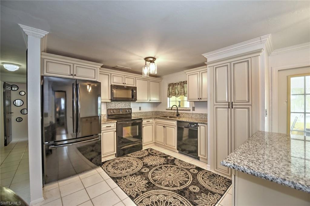 19066 Flamingo Road Fort Myers, FL 33967 - Photo 4 of 29 a kitchen with stainless steel appliances granite countertop a refrigerator stove and oven