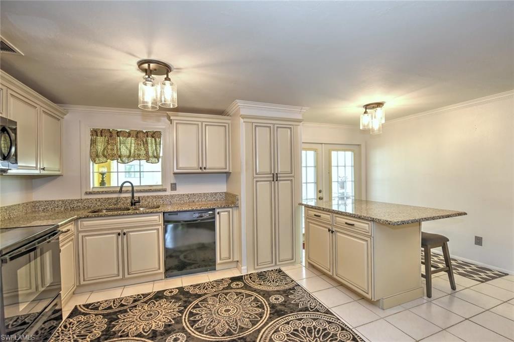 19066 Flamingo Road Fort Myers, FL 33967 - Photo 5 of 29 a kitchen with a stove a sink and a refrigerator