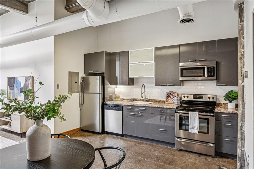 659 Auburn Avenue Northeast, Unit 229 Atlanta, GA 30312 - Photo 8 of 40 a kitchen with stainless steel appliances a sink a stove top oven a counter space and cabinets