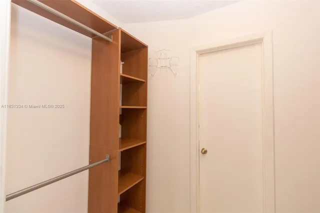 a view of walk in closet with empty racks