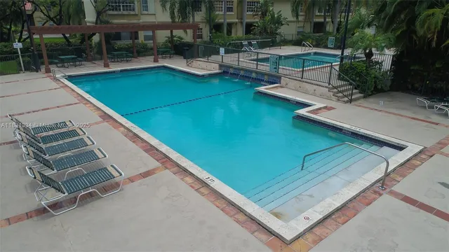 a view of a pool with chairs in patio