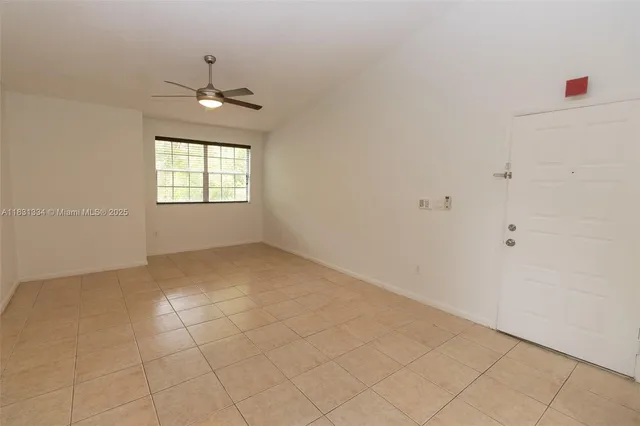 an empty room with windows and chandelier fan