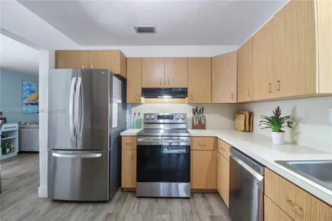 a kitchen with stainless steel appliances granite countertop a stove a sink and a refrigerator