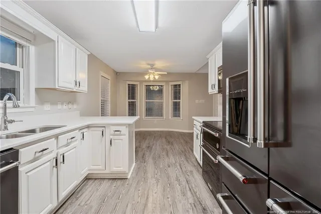 a kitchen with white cabinets and stainless steel appliances