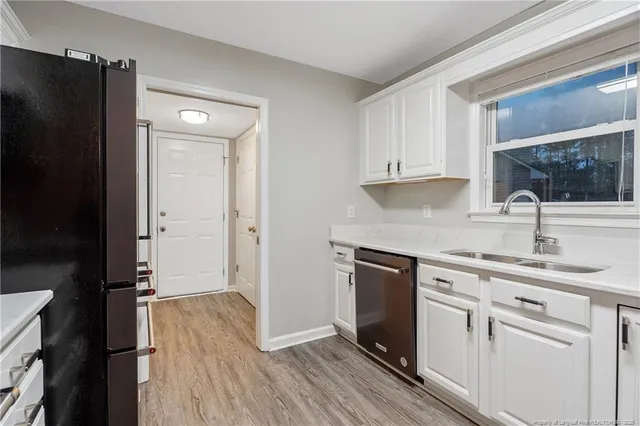a kitchen with a refrigerator sink and cabinets