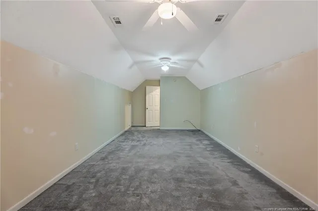 an empty room with a ceiling fan and window