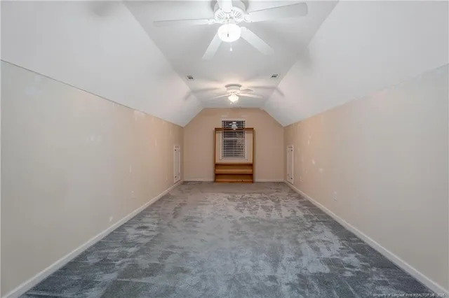 an empty room with a ceiling fan and window
