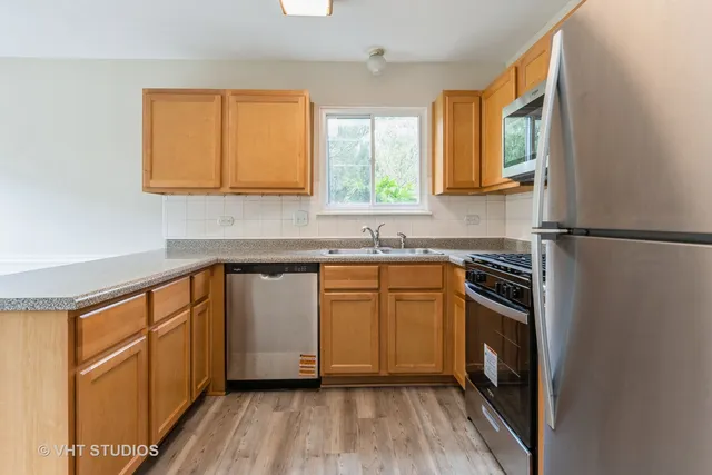a kitchen with stainless steel appliances granite countertop a stove a sink and a refrigerator
