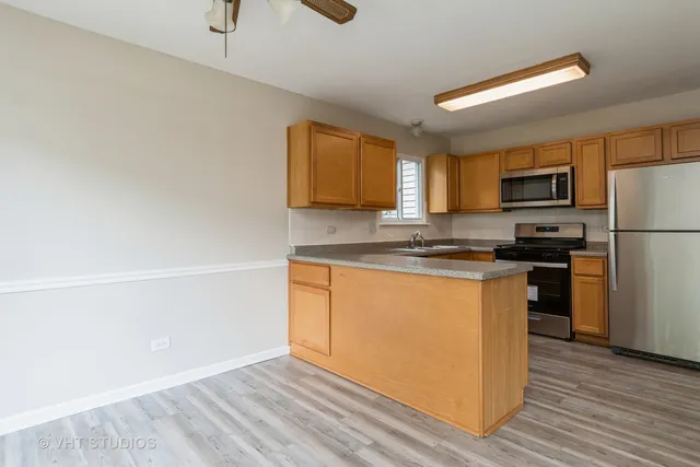 a kitchen with granite countertop a refrigerator stove top oven and sink