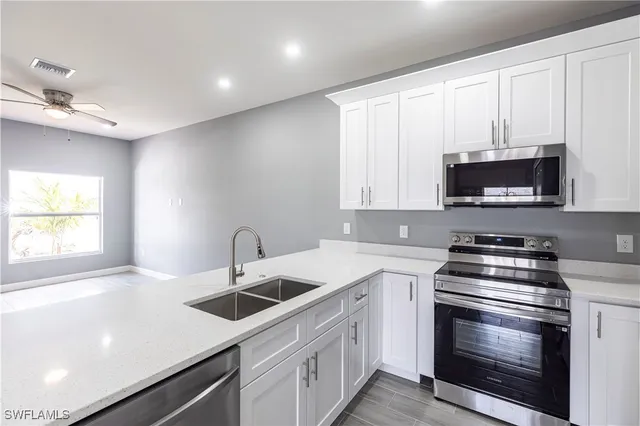 a kitchen with stainless steel appliances granite countertop a refrigerator sink and stove