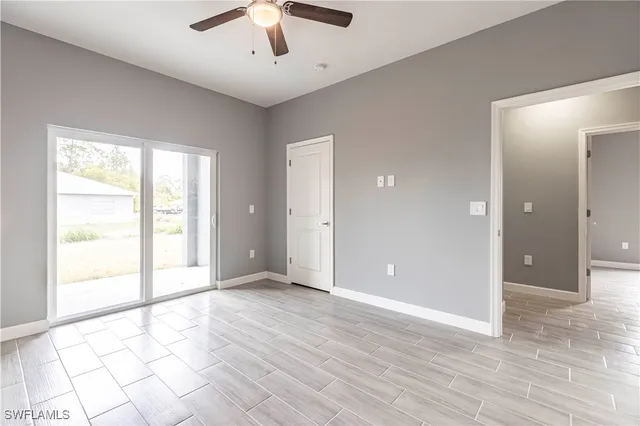 an empty room with wooden floor chandelier and entryway