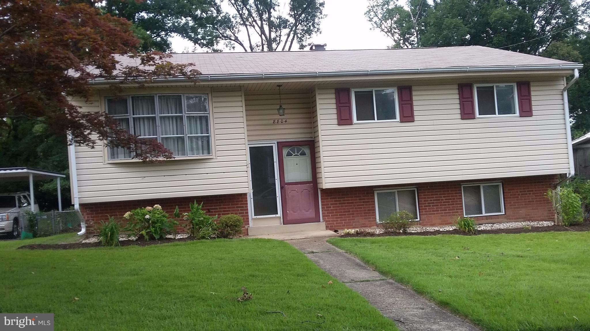 8804 Crandall Road Lanham, MD 20706 - Photo 1 of 11 a front view of a house with a garden and yard