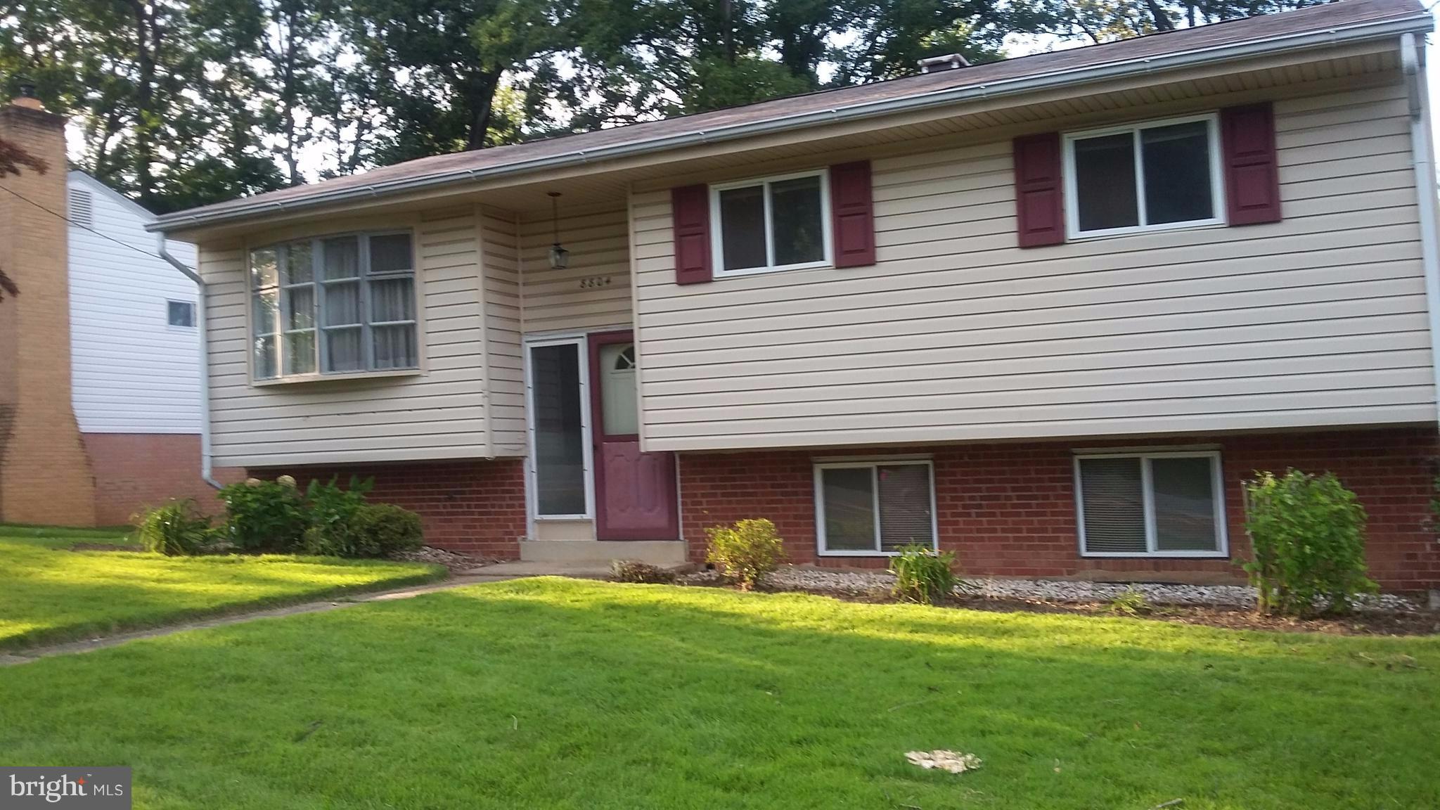 8804 Crandall Road Lanham, MD 20706 - Photo 2 of 11 a front view of a house with a yard and garage