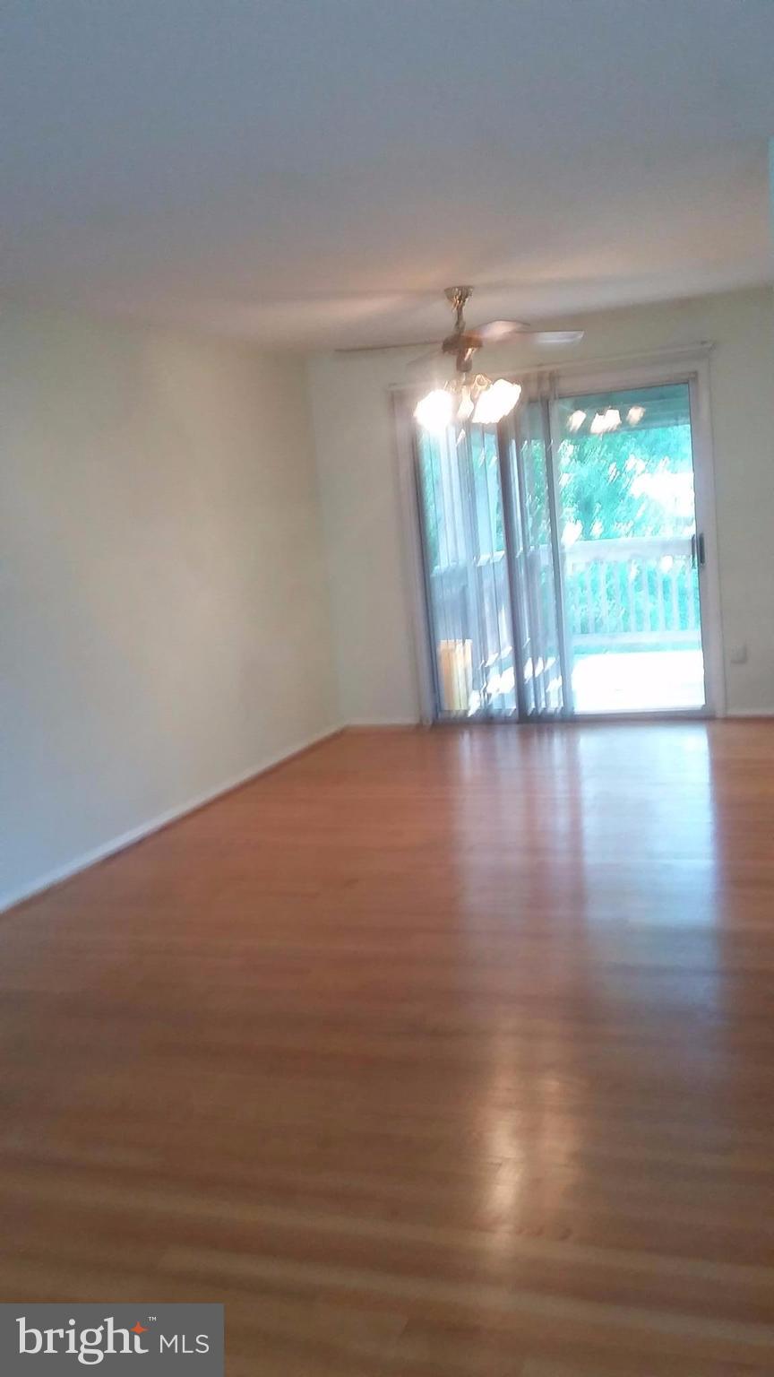 8804 Crandall Road Lanham, MD 20706 - Photo 9 of 11 a view of an empty room with wooden floor and a window