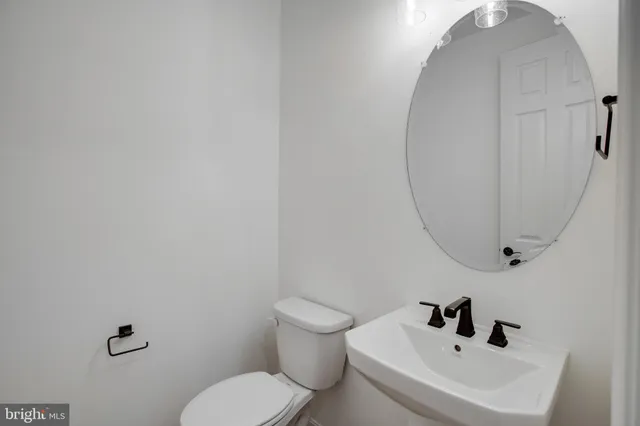 a bathroom with a sink mirror and toilet