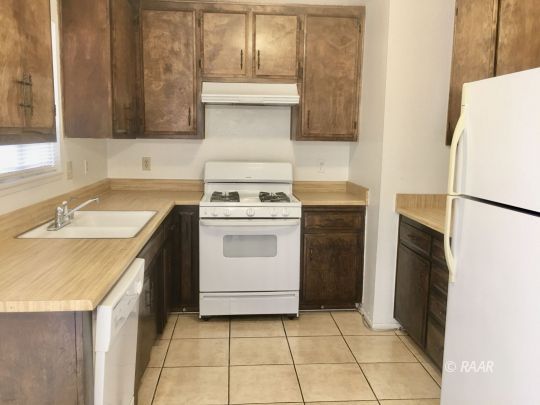 220 South Valley Street Ridgecrest, CA 93555 - Photo 6 of 17 a kitchen with a stove a sink and a refrigerator