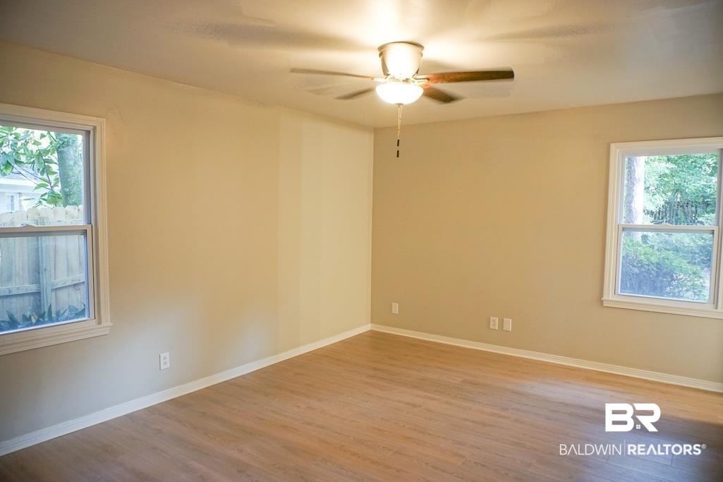 6205 Zeigler Boulevard Mobile, AL 36608 - Photo 7 of 17 Unfurnished room featuring healthy amount of natural light, wood finished floors, and a ceiling fan