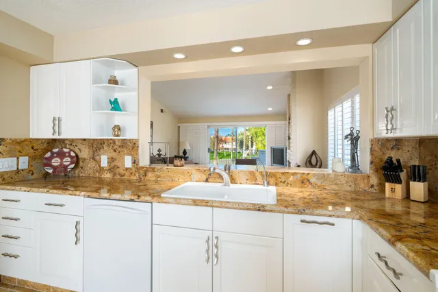 a kitchen with stainless steel appliances granite countertop a stove a refrigerator and a white cabinets