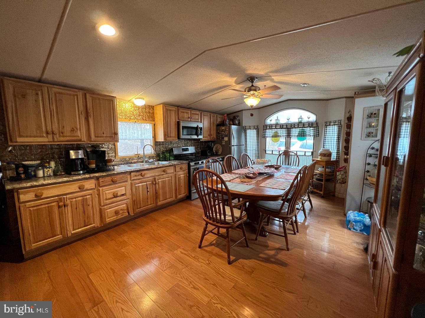 2298 Youngblood Road Great Cacapon, WV 25422 - Photo 8 of 11 a kitchen with a dining table chairs and white cabinets