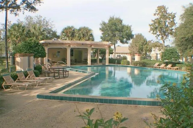 a view of backyard with swimming pool and seating space