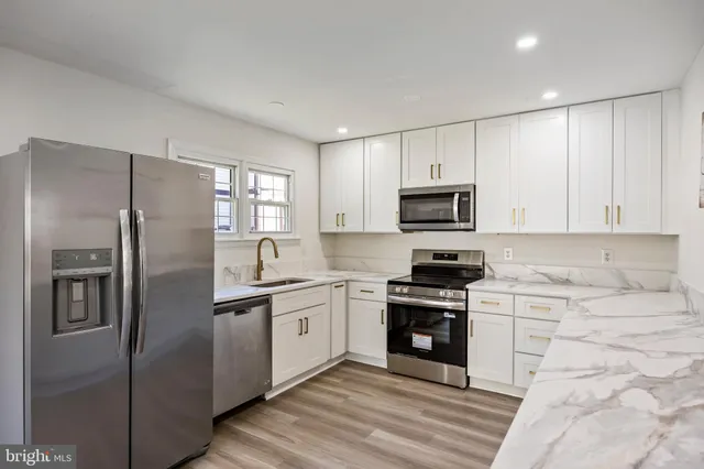 a kitchen with stainless steel appliances granite countertop a refrigerator stove top oven and sink