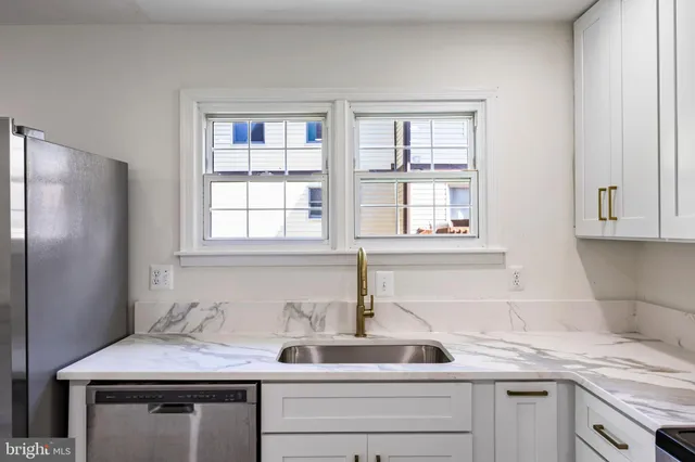 a kitchen with stainless steel appliances granite countertop a sink and a window