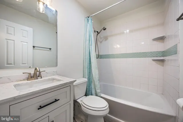 a bathroom with a sink a mirror toilet and bathtub